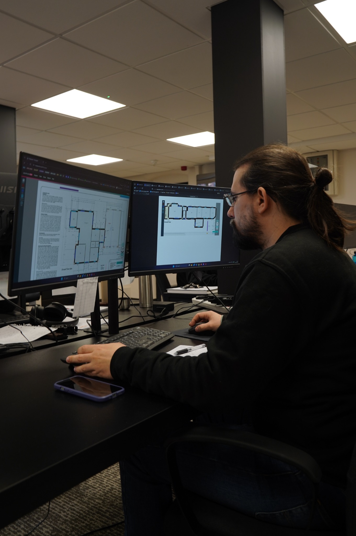Q Smart designer reviewing building plans on two monitors